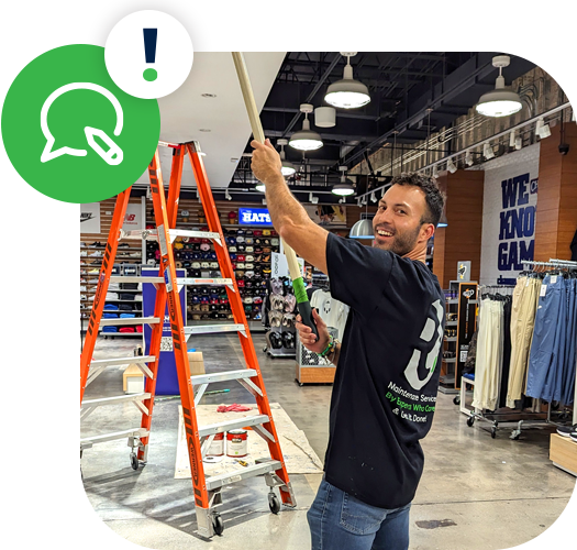 RMS team member painting the ceiling of a retail store, with a ladder in the background